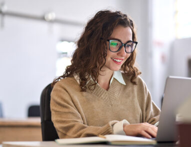 Young woman sitting at desk with laptop - This link takes you to the full article