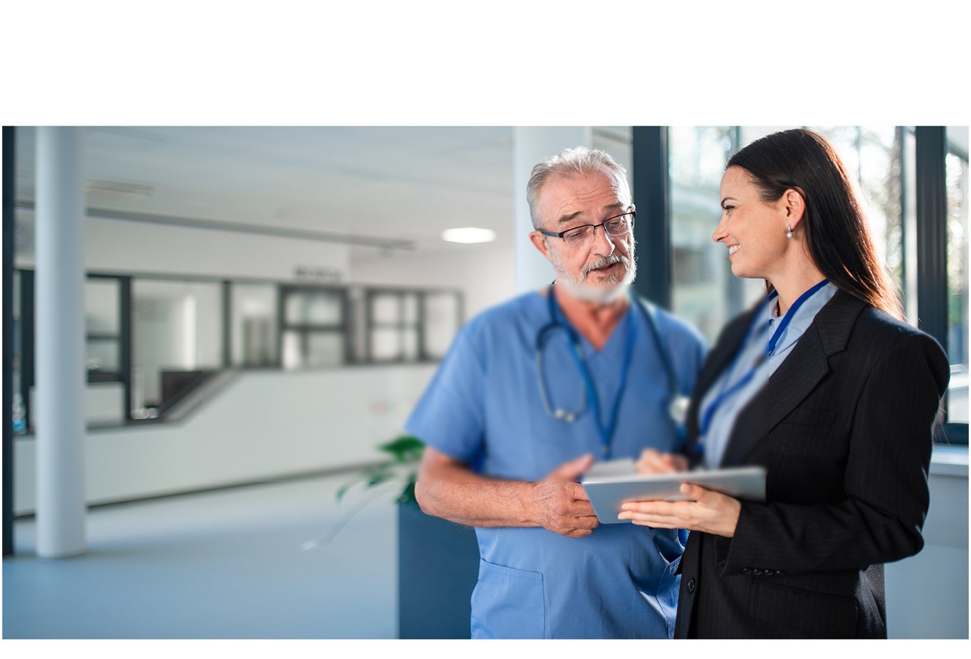 Two healthcare professionals reviewing a tablet